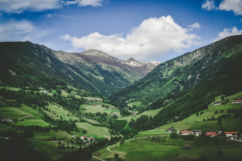 sparse buildings in a green mountain valley in austria, peaceful austrian valley 4k