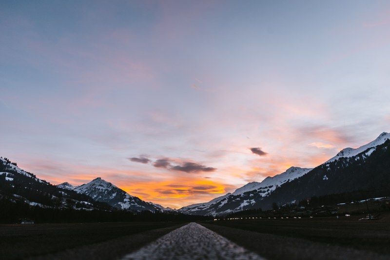 a low shot of an asphalt road running through a mountain valley in adelboden, beautiful switzerland 4k