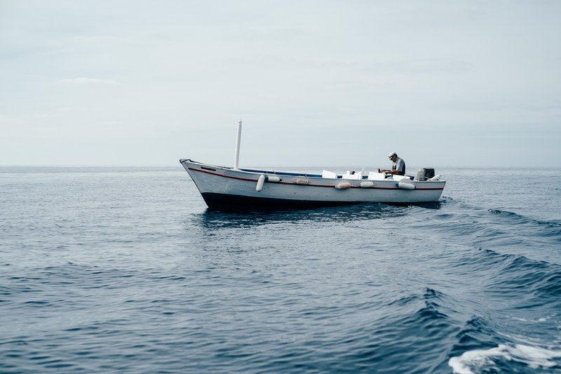 a white boat on the sea and the captain in corfu, corfu boat 4k