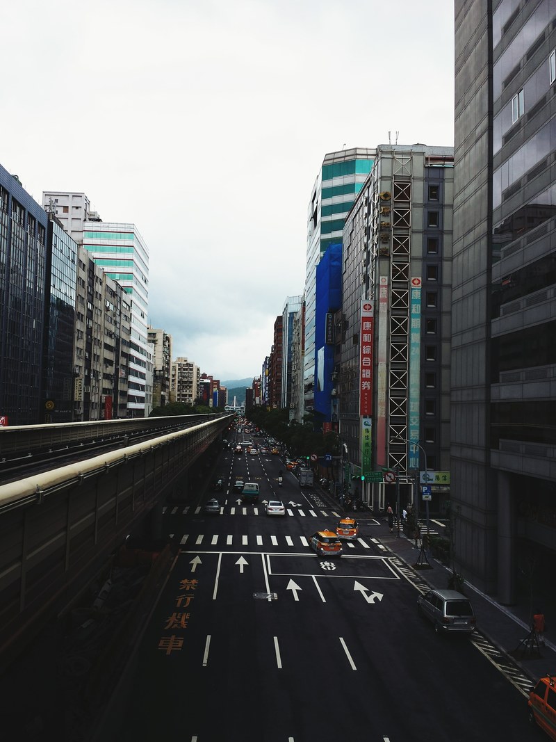 daytime traffic with taxis on urban road surrounded by downtown city buildings, downtown daytime traffic with taxis 4k