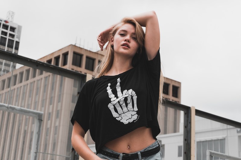 woman in a skeleton t shirt posing on a rooftop, peace sign shirt 4k