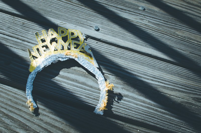 a discarded old happy new year headband on wooden floorboards ocean city, the morning after happy new year 4k
