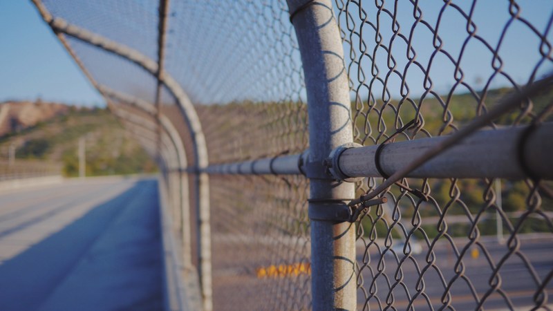 fence chain link road and barbwire 4k