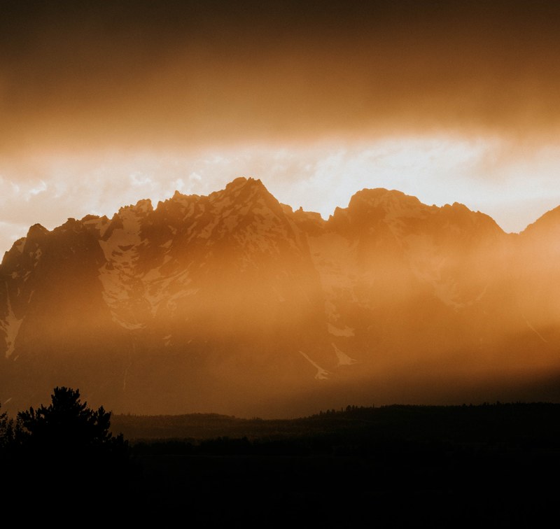 fog covered mountains below a cloudy sky during an orange sunset, _dude ranch 4k