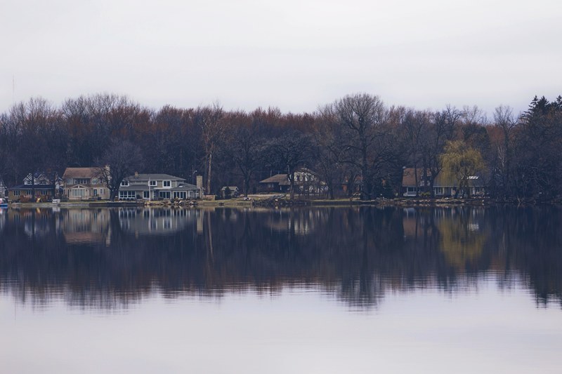 cottages on the water in the middle of the woods perfectly reflecting off the lake, _lake cottage reflection 4k