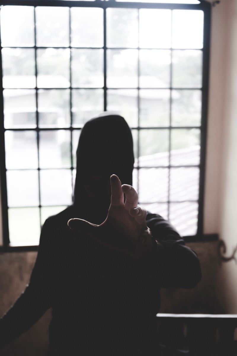 a hooded person reaching for the camera, _beholder 4k