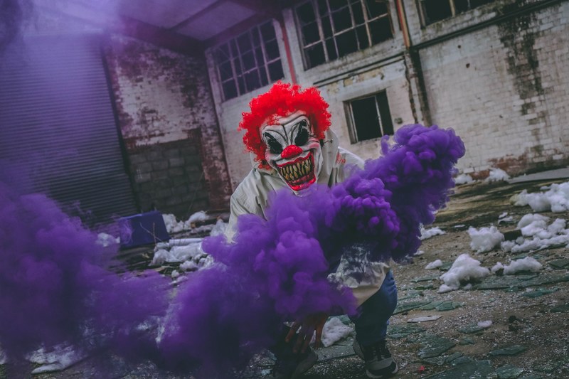 a freaky clown near urban buildings creating purple smoke, _smoking maniac 4k
