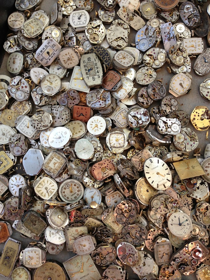 a large heap of broken antique watches and clocks, watchmakers junkyard 4k