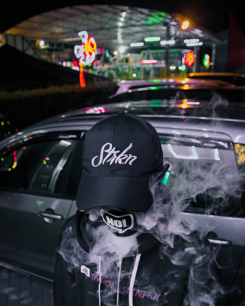 person in black and white vaping in fashion labels with colorful neon signs in the background, break the limit 4k