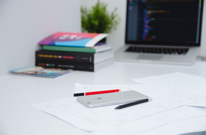 a smartphone on top of papers next to a laptop books and pens, _smartphone on desk 4k