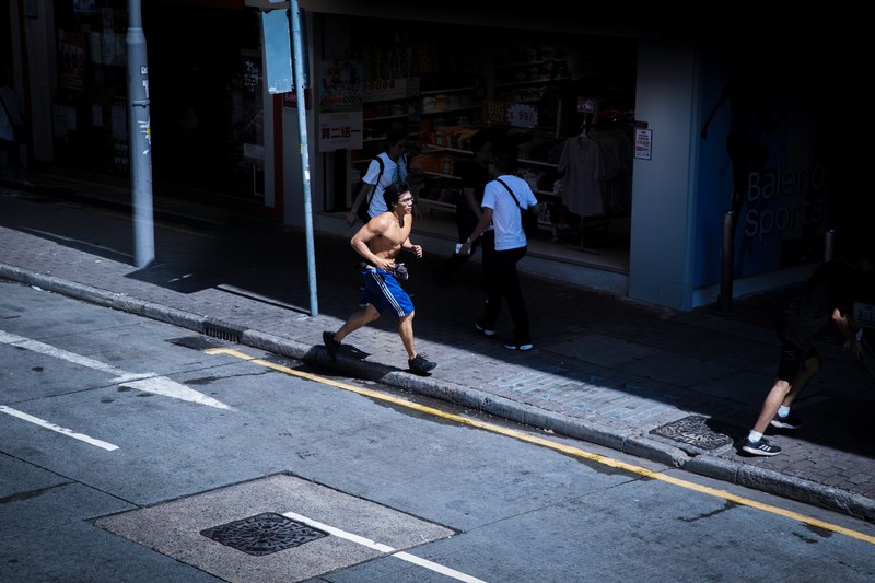 a shirtless man running down a city sidewalk, _guy running on sidewalk 4k