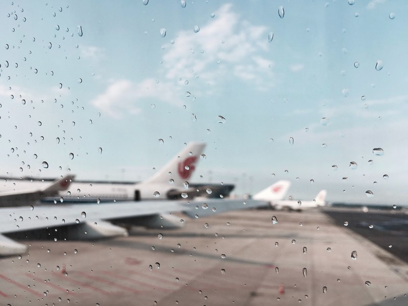 planes at an airport taken with a rain covered camera, _raindrops at the airport 4k