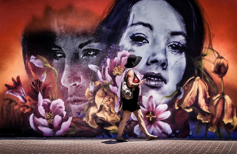 woman walking by the wall mural at bondi beach, woman in front of mural 4k