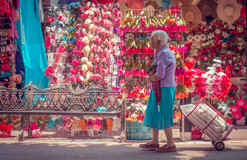 an older asian woman with white hair pulling her cart along a flower vendor, _flowers old 4k