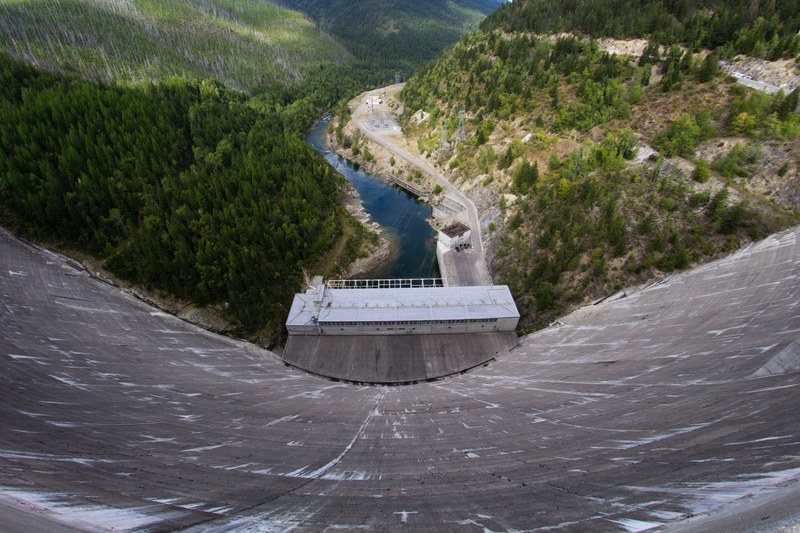 view from the top of a tall concrete dam on the river below, view from a dam 4k