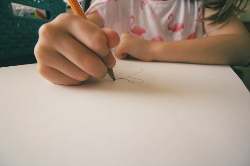 a little girl drawing a picture on paper with a pencil, _kid pencil drawing 4k