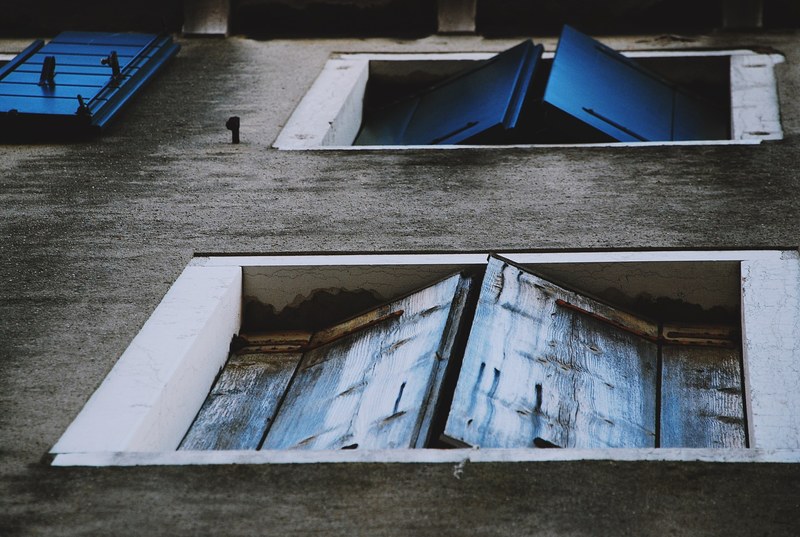 worn blue window shutters from below with grey wall and white frame metropolitan city of venice, blue window shutters in venice 4k