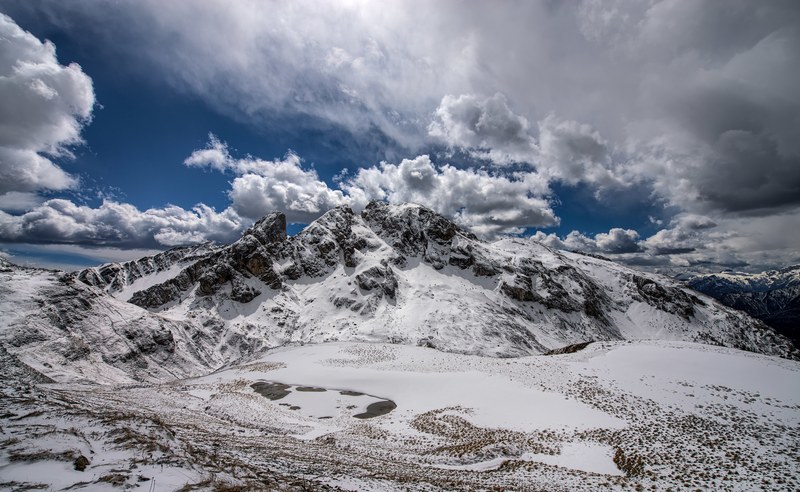 mountain landscape with snow capped peaks under a cloudy sky, snowy mountain peaks 4k