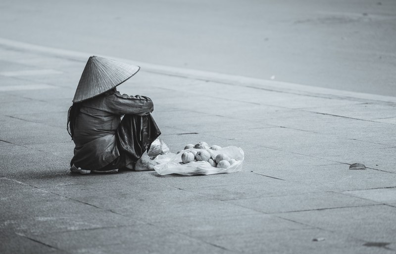 a woman sitting on the ground wearing an asian rain hat, _asian rain hat 4k