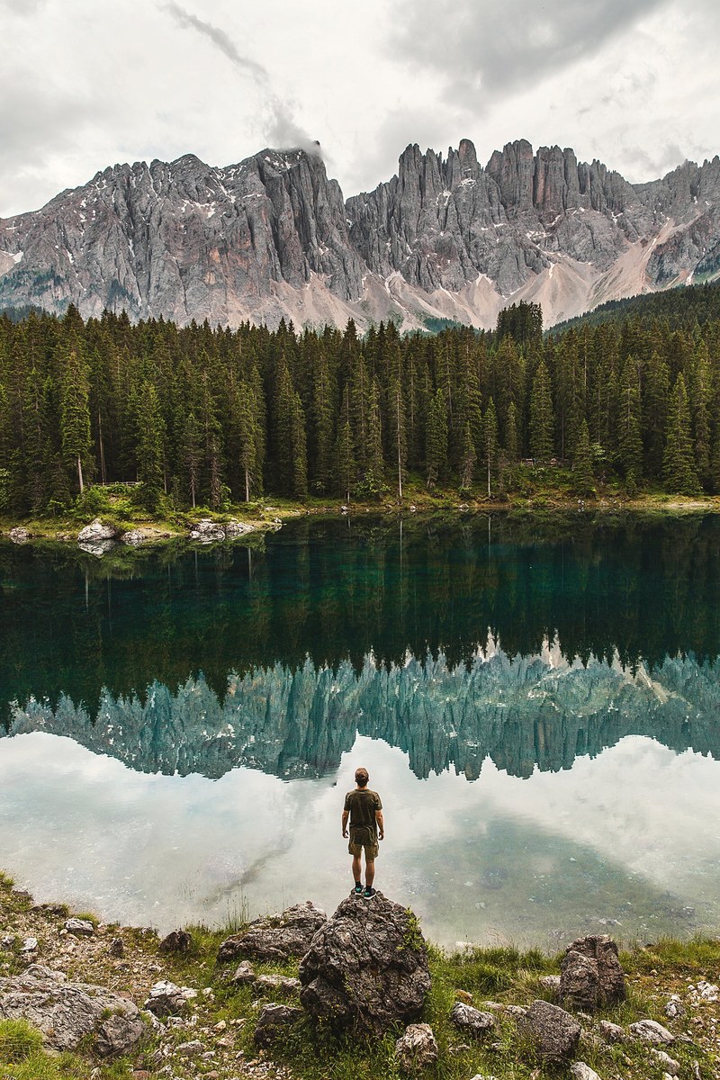 a man standing on a boulder staring at a mountain pond, _staring mountain pond 4k