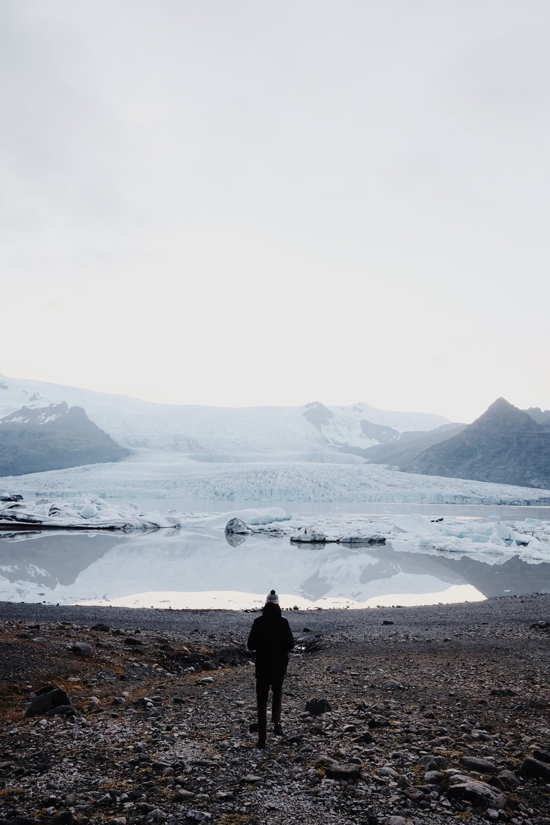 a person looking at a snow covered mountain pond, _glacier 4k
