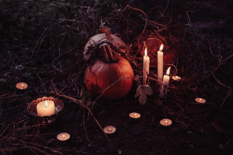pumpkins with branches on the ground with lit candles by them in barcelo, pumpkins with candles 4k