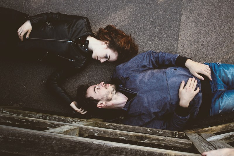 overhead shot of man and woman laying on backs on walkway outdoors, i could fall asleep here 4k