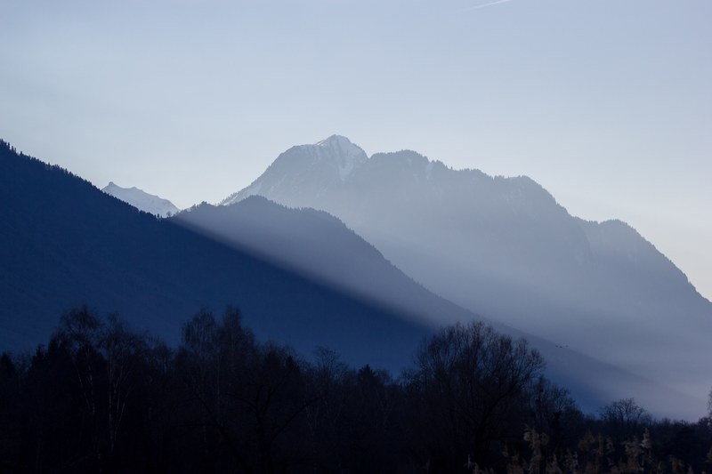a hazy shot of wooded mountain ridges against a light blue sky, noville mountains in the morning 4k