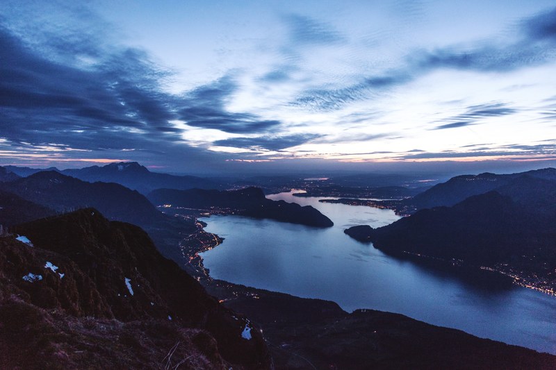 evening sky over a lake in the mountains with a town on its shores, evening sky over a long lake 4k