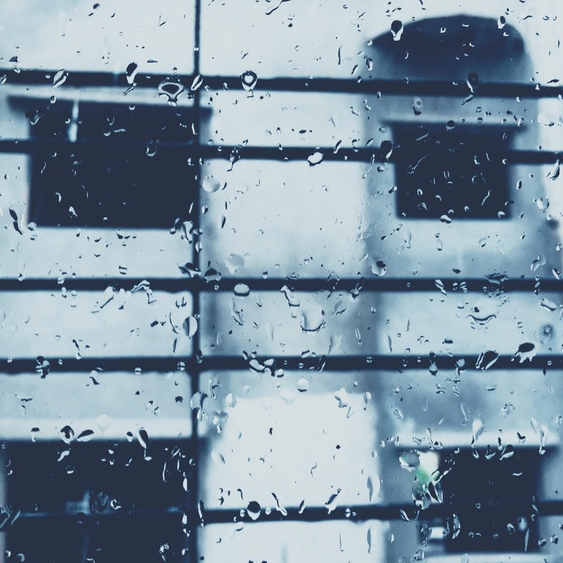 room interior looking through rainy window at horizontal bars and unfocused background, rainy window with bars 4k