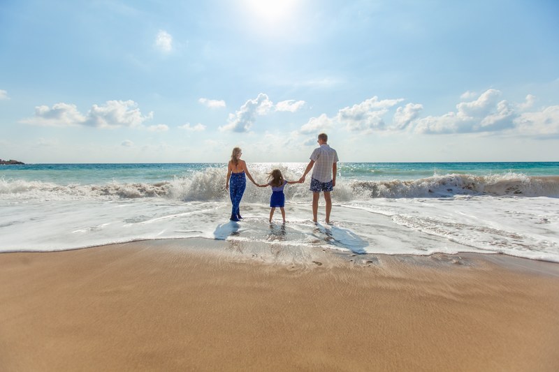 mother daughter and father holding hands in a line on a beach during the daytime, _summer in paphos 4k