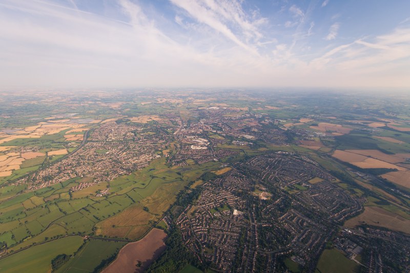 rural towns form maze like patterns in a country landscape, above a countryside town 4k