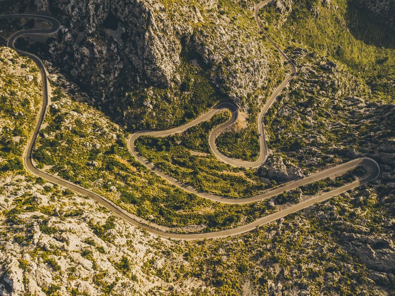 an aerial view of a large curvy road traveling through country mountains, _road to sa calobra 4k