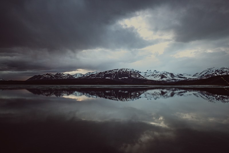 a snowcapped mountain range reflecting against paxson lake, paxson lake reflection 4k