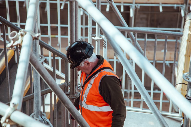 a construction worker dressed with proper equipment at london work site, at a building site 4k