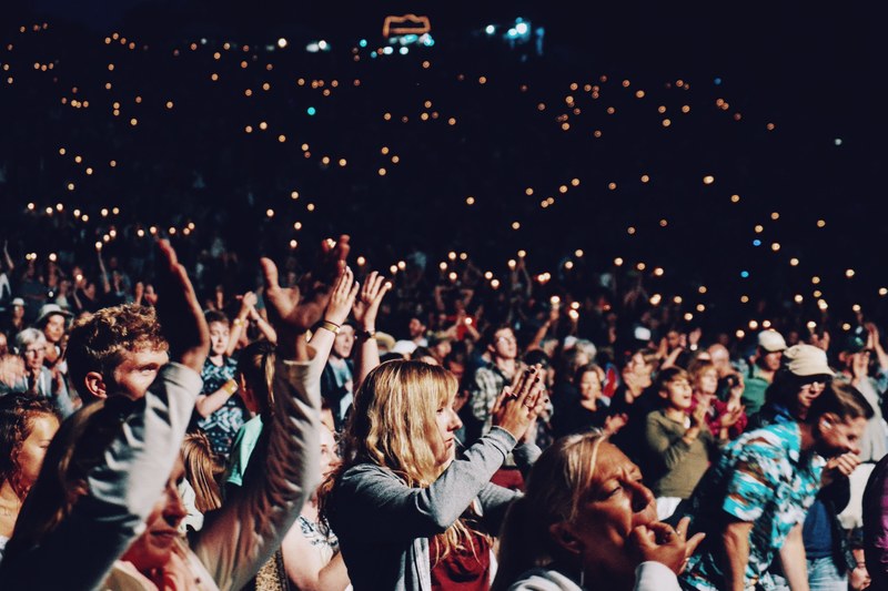 a crowd of people cheering at an evening concert, cheering concertgoers 4k