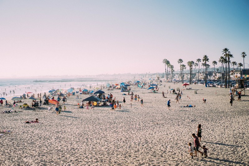 people enjoying the tropical sun sea and sand at a fairly crowded newport beach ca, people enjoying newport beach 4k