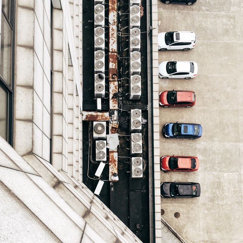 looking down from a building at the parking lot and air conditioner units at wuhan, drone view parked cars 4k