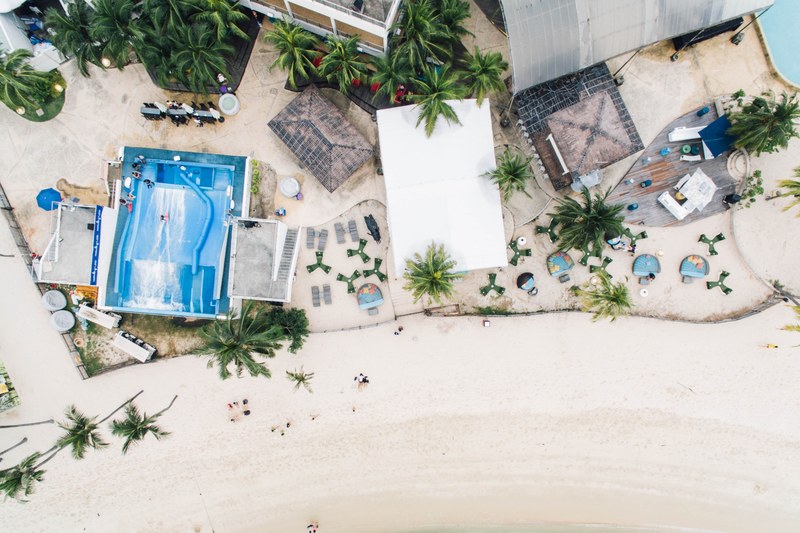 drone aerial view of the coastal resort buildings on the sand beach at sentosa, coastline drone view 4k
