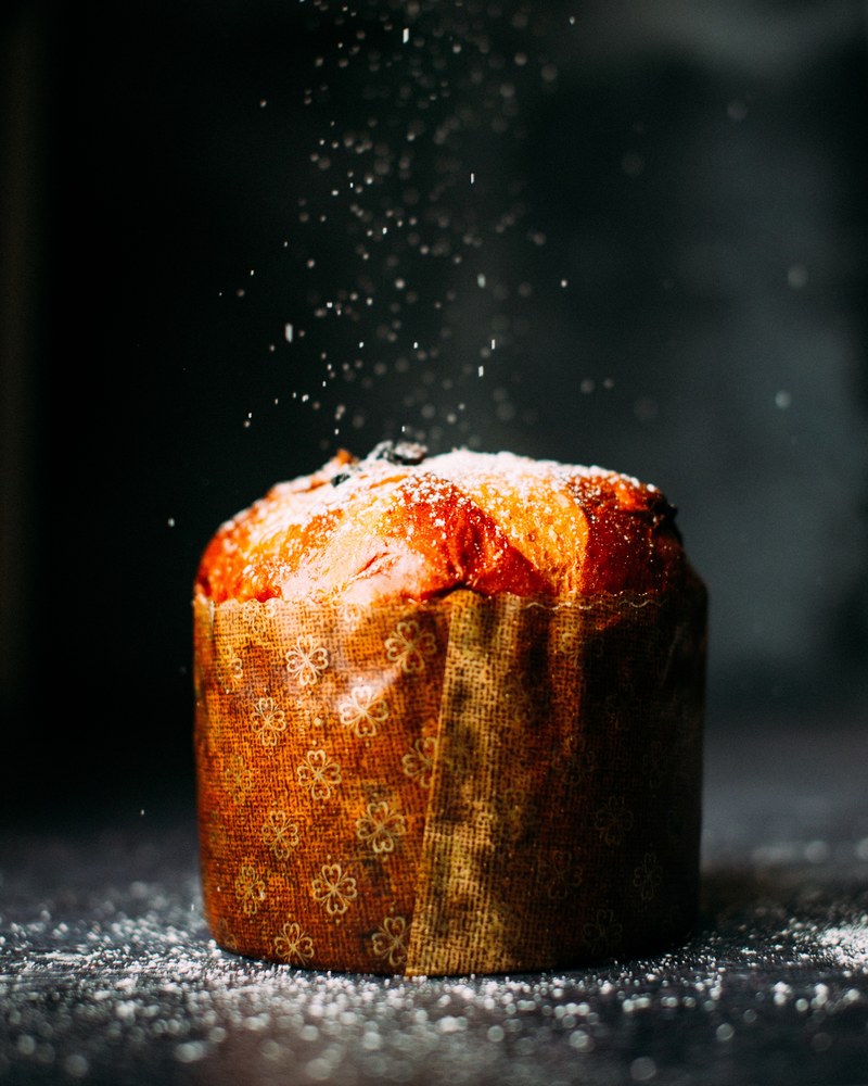 a muffin wrapped in paper and sprinkled with powdered sugar, bakery muffin 4k