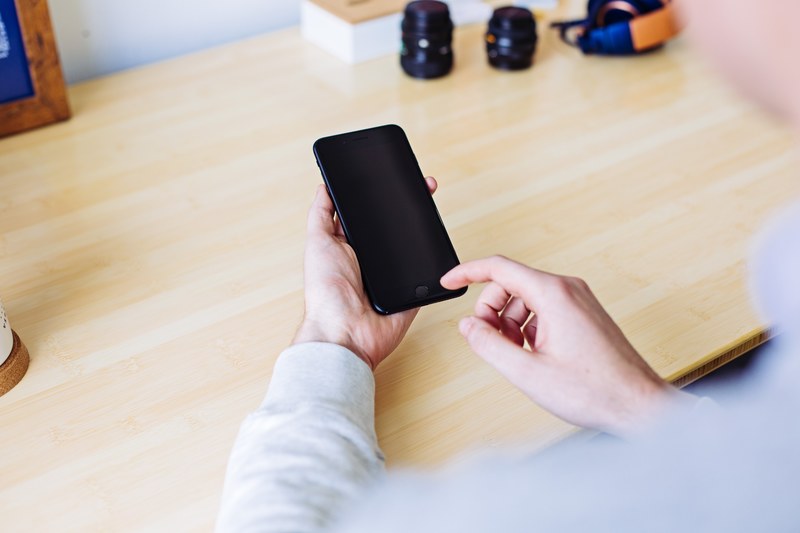 person working on their phone at their home office desk, iphone display 4k