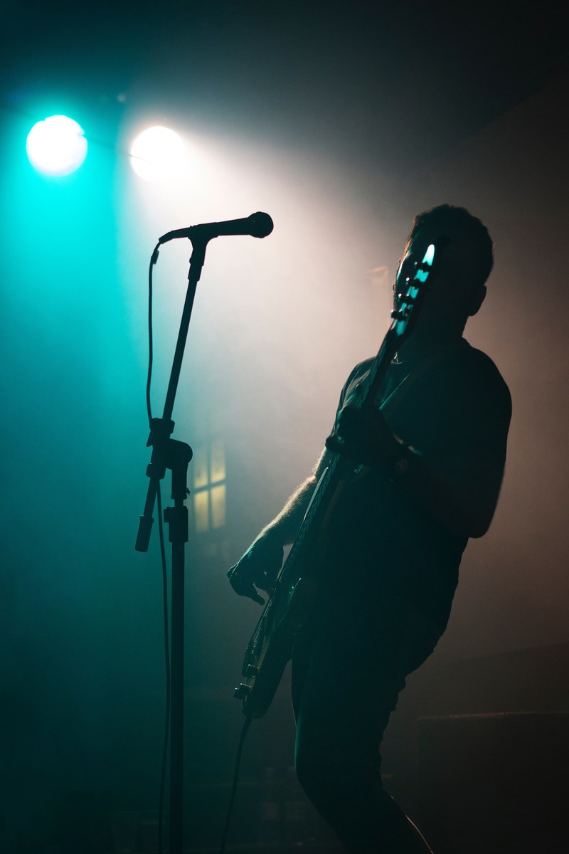 a guitarist leaning back during a stage performance in the wall caf, breakfasters 4k