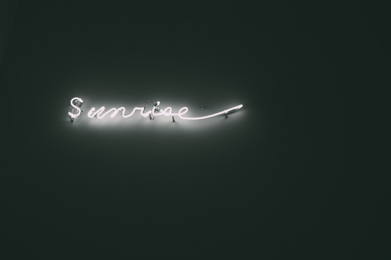 sunrise bright white neon sign on black background at mori art museum, neon sunrise sign 4k