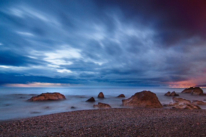 timelapse photo of the ocean from a pebble beach at playa del penn del cuervo after sunset, timelapse photo of ocean 4k