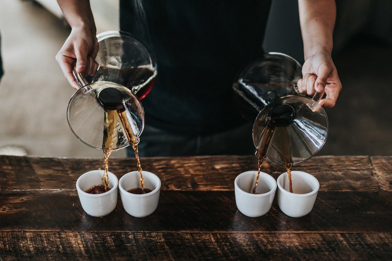 a barista pouring coffee to four cups at once, skillful barista 4k