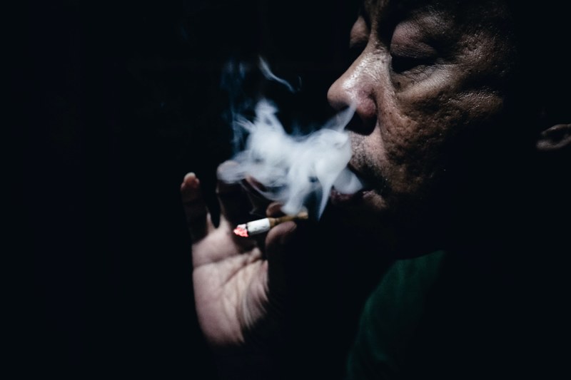 dark skinned old man smoking a cigarette in the dark, i smoke therefore i am_ 4k