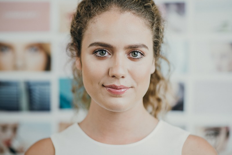 woman with subtle natural makeup smiling softly, glossy lips 4k