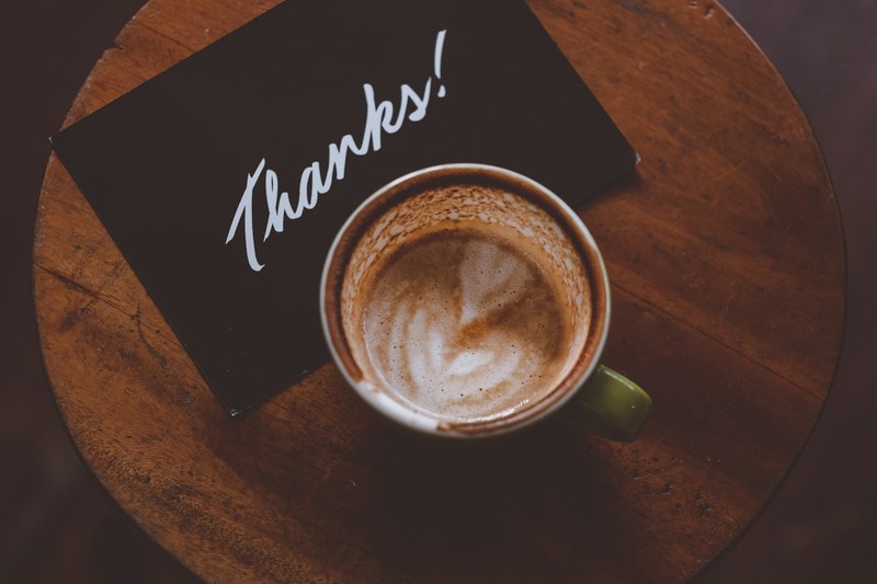 an overhead shot of a thank you card next to a cup of coffee, thanks postcard and latte 4k
