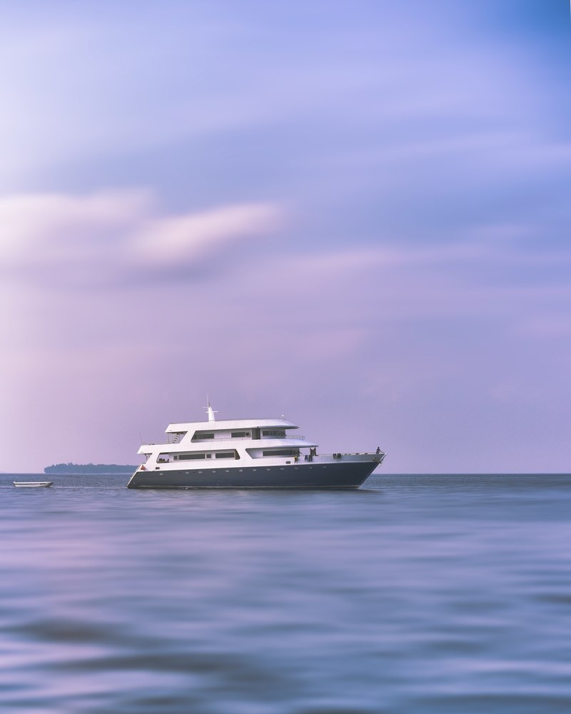 a yacht with a smaller boat on a calm sea in maafushi, idyll 4k