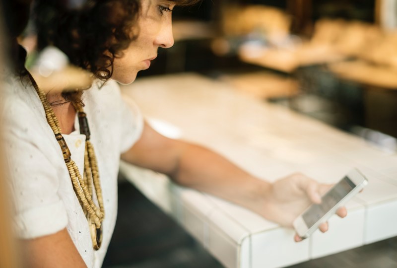 a woman in a large necklace using an iphone, woman using an iphone 4k